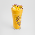 Glass of yellow smoothie with passion fruit slices on a white background